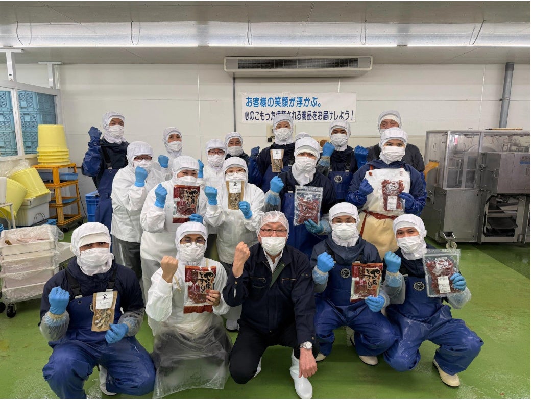 商品を手に笑顔を見せる野口水産の皆さん